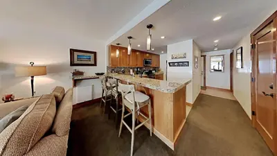 a kitchen and living room with a couch and a bar at Renovated 2 Bedroom Condo with Elevator Access! in Mammoth Lakes