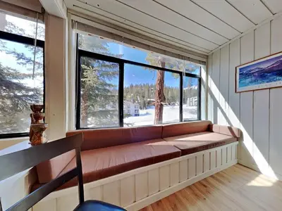 a couch in a room with a large window at Walk To Lifts! Remodeled 2 Bedroom Condo in Mammoth Lakes