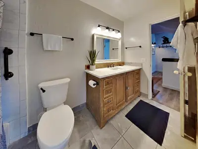 a bathroom with a toilet and a sink and a mirror at Remodeled Spacious Cozy Condo Great For Families! in Mammoth Lakes