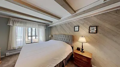 a bedroom with a large bed and a window at Beautiful 2 BR Condo with Mountain View! in Mammoth Lakes