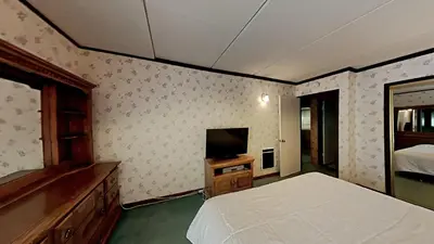 a bedroom with a bed and a flat screen tv at Retro 3 Bed 3 Bath Condo with Mountain View! in Mammoth Lakes