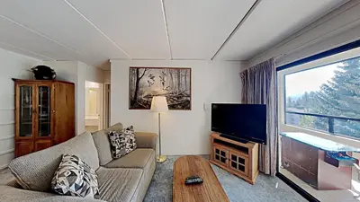 a living room with a couch and a flat screen tv at Great 2 Bedroom Condo with Mountain View! in Mammoth Lakes