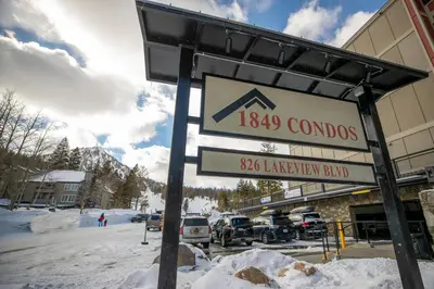 a sign in front of a building in the snow at 2 Bed 2 Bath Condo Steps Away From Recreation! in Mammoth Lakes