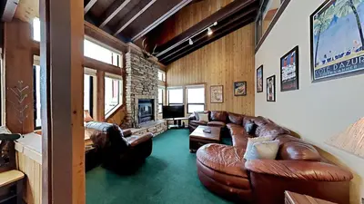 a living room with leather couches and a tv at Beautifully Remodeled 4 Bedroom Condo in Mammoth Lakes
