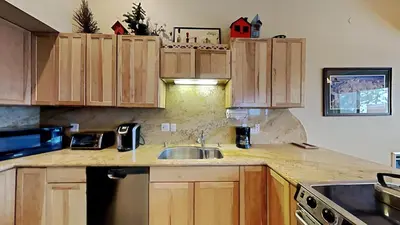 a kitchen with wooden cabinets and a sink at Beautifully Remodeled 4 Bedroom Condo in Mammoth Lakes