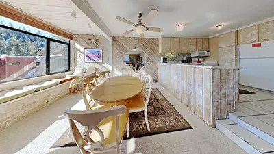 a kitchen with a table and chairs and a counter at Upgraded 2 Bedroom Condo with Pool in Mammoth Lakes
