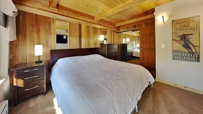 a bedroom with a large bed and a wooden wall at Lakeview 826 Condo #302 Condo in Mammoth Lakes