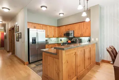 a kitchen with wooden cabinets and a stainless steel refrigerator at Cabins 13 in Old Mammoth