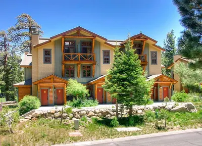 a large house with a tree in front of it at Cabins 13 in Old Mammoth