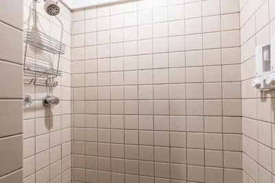 a bathroom with white tiled walls and a shower at Canyon Ski and Racquet 16 in Mammoth Lakes