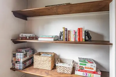 a book shelf with books and boxes on it at Canyon Ski and Racquet 16 in Mammoth Lakes