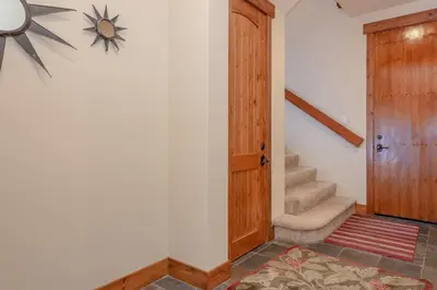 a hallway with a wooden door and a staircase at Lodges 1140- Spacious Townhome on Golf Course in Old Mammoth