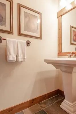 a bathroom with a sink and a mirror and towels at Lodges 1140- Spacious Townhome on Golf Course in Old Mammoth