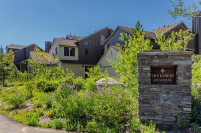 a sign in a garden with houses in the background at Lodges 1140- Spacious Townhome on Golf Course in Old Mammoth