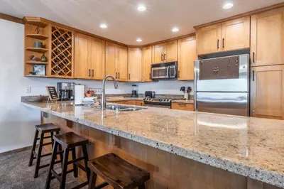 a kitchen with wooden cabinets and a stainless steel refrigerator at Mountainback 15 in Old Mammoth