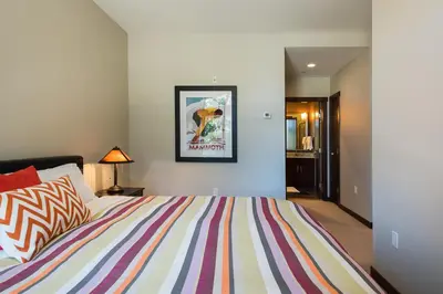 a bedroom with a bed with a colorful striped comforter at Solstice 21 in Mammoth Lakes