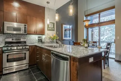 a kitchen with stainless steel appliances and wooden cabinets at Solstice 21 in Mammoth Lakes