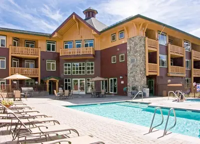 a resort with a pool and chairs and a building at Sunstone 325 in Old Mammoth