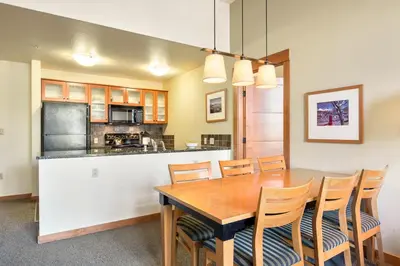 a kitchen and dining room with a wooden table and chairs at Village 2105 in Mammoth Lakes