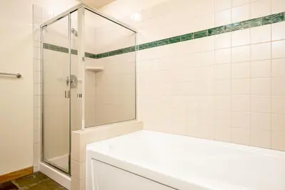 a white bathroom with a shower and a tub at Village 2105 in Mammoth Lakes