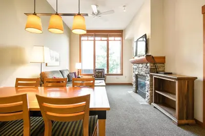 a living room with a table and a fireplace at Village 2105 in Mammoth Lakes