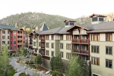 a row of apartment buildings with a mountain in the background at Village 3311 in Mammoth Lakes