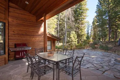 a patio with a table and chairs in front of a cabin at Northstar - Sierra Gold Home in Kingswood Estates