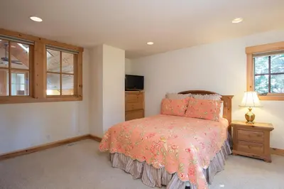 a bedroom with a bed and a tv and windows at Northstar - Sierra Gold Home in Kingswood Estates