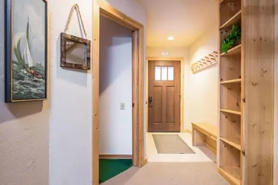 a hallway with a wooden door and shelves at Northstar - Ski Trail Condo in Kingswood Estates
