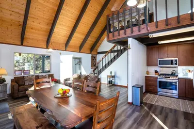 a dining room and living room with a wooden table at North Shore - Cozy Cabin in Wood Vista
