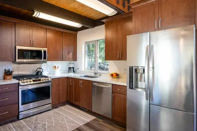 a kitchen with wooden cabinets and stainless steel appliances at North Shore - Cozy Cabin in Wood Vista