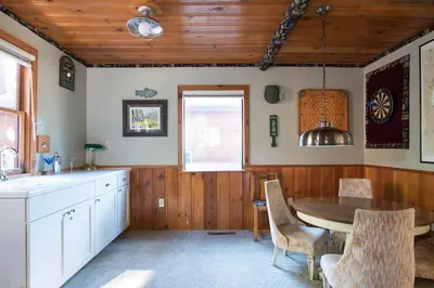 a kitchen with a table and chairs in a room at North Shore - Dancing Antler in Wood Vista