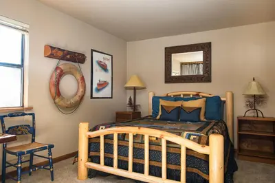 a bedroom with a wooden bed and a mirror at North Shore - Dancing Antler in Wood Vista