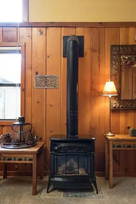 a stove in a room with a table and a lamp at North Shore - Dancing Antler in Wood Vista