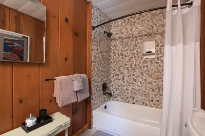 a bathroom with a white tub and a sink and a shower at North Shore - Dancing Antler in Wood Vista