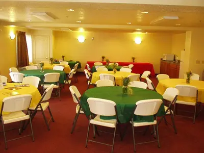 a room with tables and chairs with yellow and green tables at Murphys Suites in Murphys