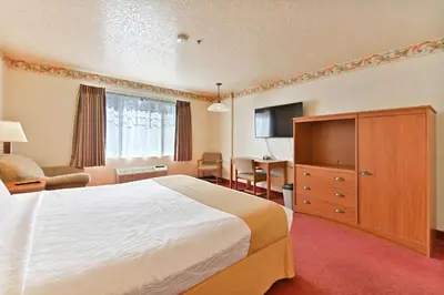 a hotel room with a large bed and a desk at Murphys Suites in Murphys