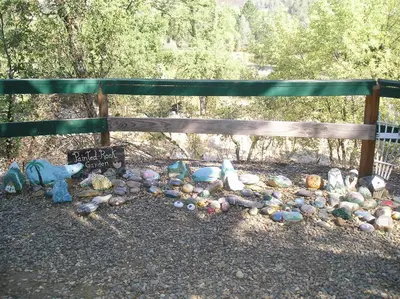 a pile of rocks under a wooden fence at Ponderosa Camping Resort One-Bedroom Cabin 4 in Lotus