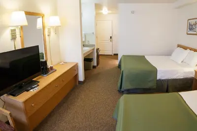 a hotel room with two beds and a flat screen tv at Murphys Inn Motel in Murphys