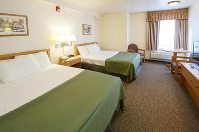 a hotel room with two beds and a desk at Murphys Inn Motel in Murphys