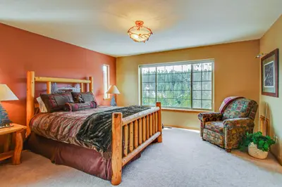a bedroom with a bed and a chair and a window at Hillside View Home in Truckee