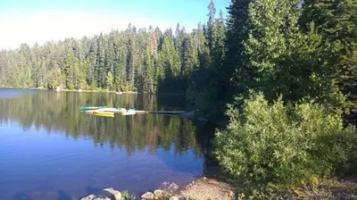 a lake with a boat in the middle of it at Snowflower Camping Resort Cabin 3 in Emigrant Gap