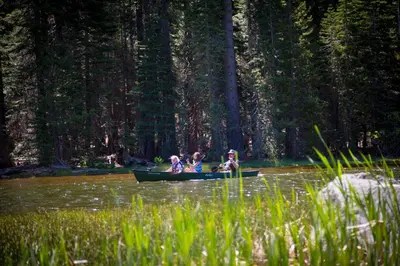 a group of people in a canoe on a river at Snowflower Camping Resort Wheelchair Accessible Cottage 8 in Emigrant Gap