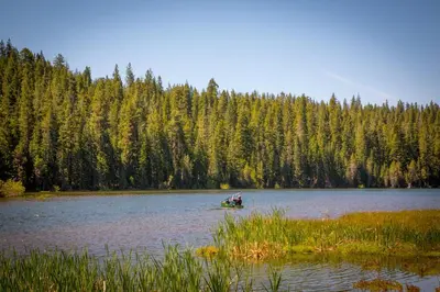 a group of people in a boat on a lake at Snowflower Camping Resort Wheelchair Accessible Cottage 8 in Emigrant Gap