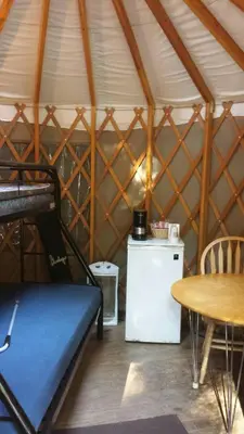 a room with a bed and a table in a yurt at Snowflower Camping Resort 12 ft. Yurt 9 in Emigrant Gap