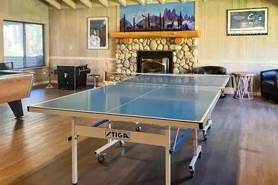 a ping pong table in a room with a fireplace at Sunshine Sanctuary in Mammoth Lakes