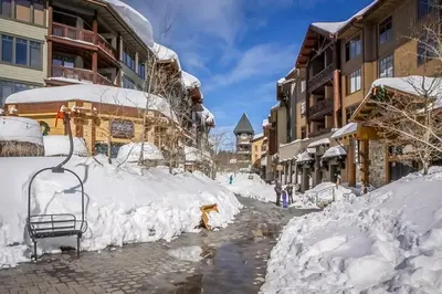 a street covered in snow next to buildings at The Bridges 203 in Mammoth Lakes