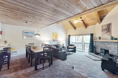 a living room with a table and a fireplace at Courchevel 48 in Mammoth Lakes