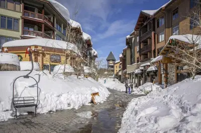 a street covered in snow next to buildings at Discovery 4 119 in Mammoth Lakes