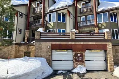 a apartment building with two garage doors in the snow at Eagle Run 113 in Mammoth Lakes